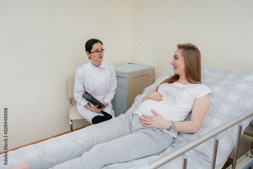 The doctor advises and serves a young pregnant girl in a medical clinic. Medical examination The doctor advises and serves a young pregnant girl in a medical clinic. Medical examination