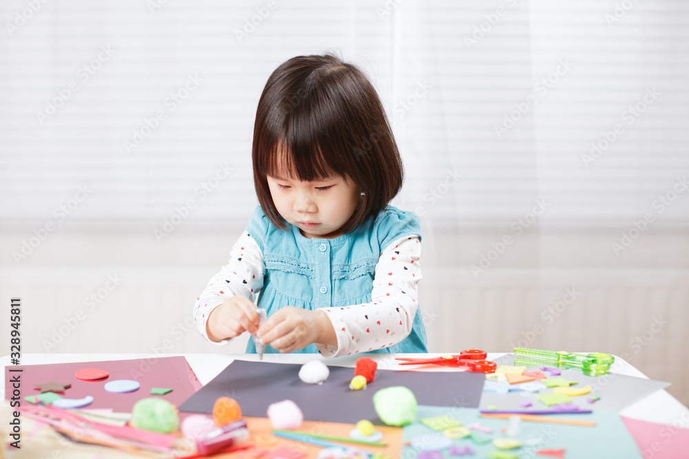 toddler girl learn making Origami at home against white background toddler girl learn making Origami at home against white background