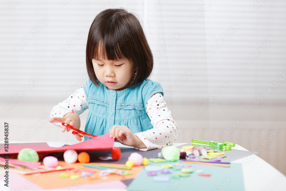 toddler girl learn making Origami at home against white background toddler girl learn making Origami at home against white background