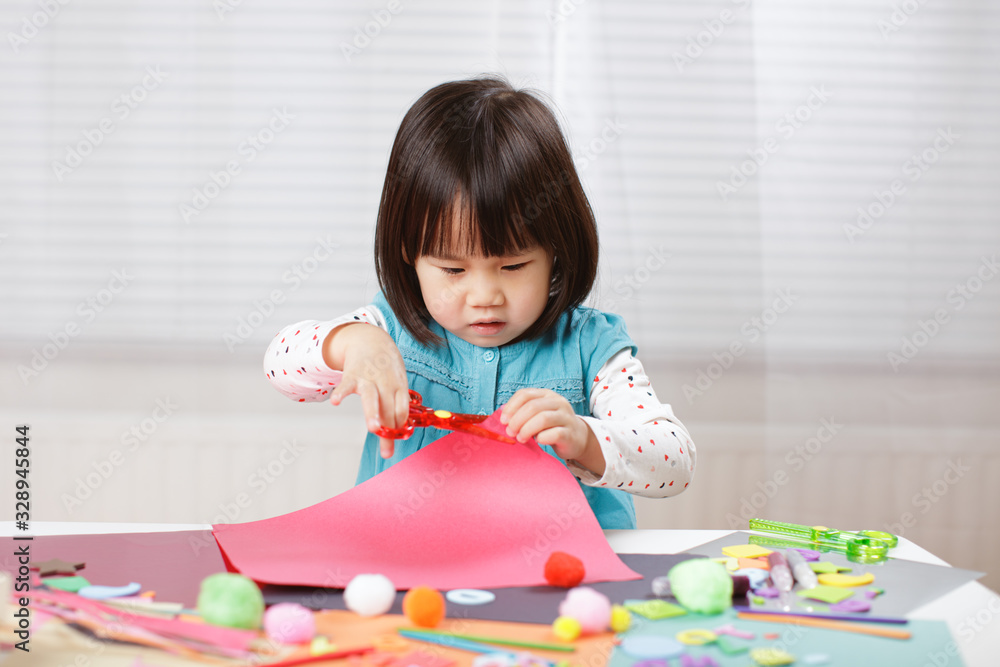 toddler girl learn making Origami at home against white background toddler girl learn making Origami at home against white background