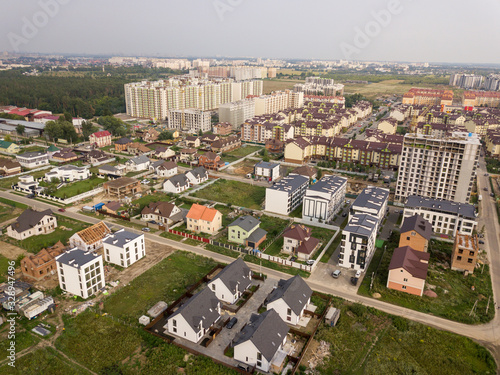 Suburban development of neighborhoods with high-rise buildings and one-story buildings with forest