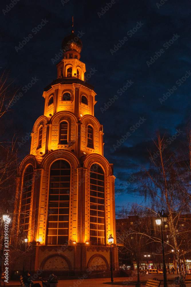 Side view of bell tower highlighted by flashlights. Venus shining in the dawn sky Side view of bell tower highlighted by flashlights. Venus shining in the dawn sky