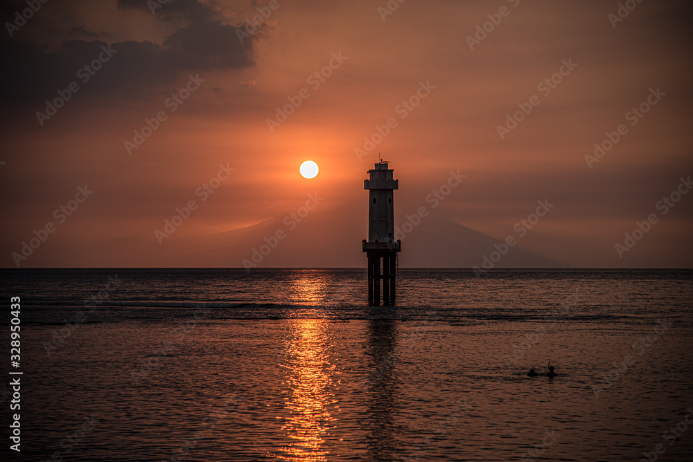 Sonnenuntergang mit Leuchtturm und Vulkan