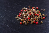 mix of peppercorns on a dark stone background