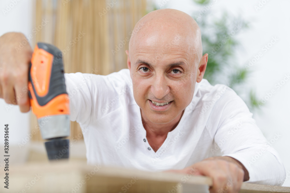 man is assembling furniture drilling metal guides to the board man is assembling furniture drilling metal guides to the board