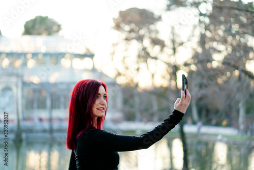 Redhead dancer using her smartphone in Madrid's Retiro park