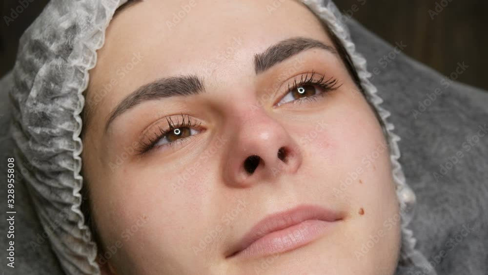 Preparation for permanent lip make-up. The face of a young girl in a special hat and real, not tattooed lips. Preparation for permanent lip make-up. The face of a young girl in a special hat and real, not tattooed lips.