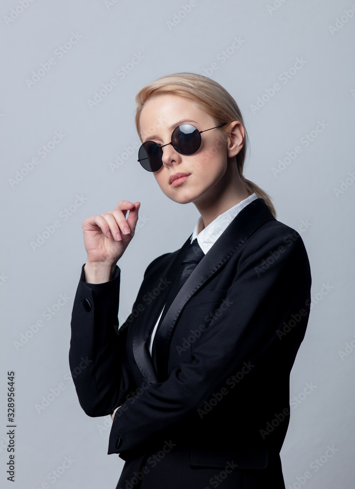 Style businesswoman in a classic black business suit and sunglasses Style businesswoman in a classic black business suit and sunglasses