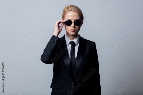 Style businesswoman in a classic black business suit and sunglasses photo