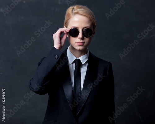 Style businesswoman in a classic black business suit and sunglasses