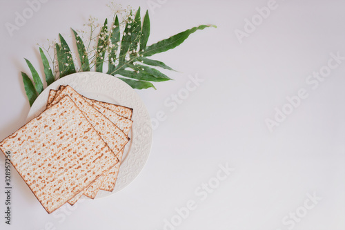 Passover background with matzoh and spring flower ranunculus. Top view with copy space. Happy Passover Spring Festive season greeting card. Jewish holidays arrangement photo