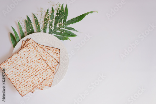 Passover background with matzoh and spring flower ranunculus. Top view with copy space. Happy Passover Spring Festive season greeting card. Jewish holidays arrangement