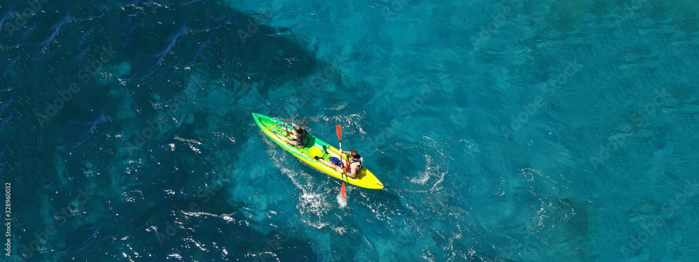 Aerial drone ultra wide photo of couple practising sport kayak in tropical exotic bay with emerald clear sea