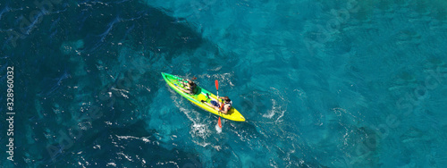 Aerial drone ultra wide photo of couple practising sport kayak in tropical exotic bay with emerald clear sea