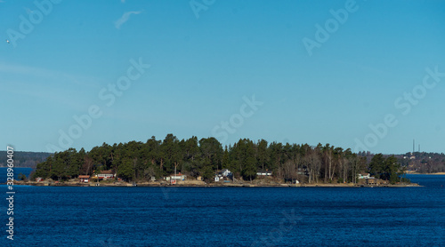 Picturesque summer houses painted in traditional falun red on dwellings island of the Stockholm archipelago in the Baltic Sea in the early morning. photo