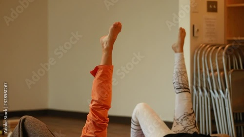 Static selective focus of woman doing uttanpadasana double leg raise pose doing angle rotation while in slow yoga for breast cancer healing photo