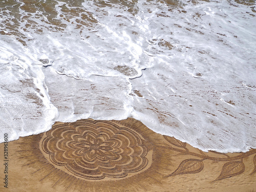 Beautiful beach mandala with a flower and dolphins in Albufeira in Portugal