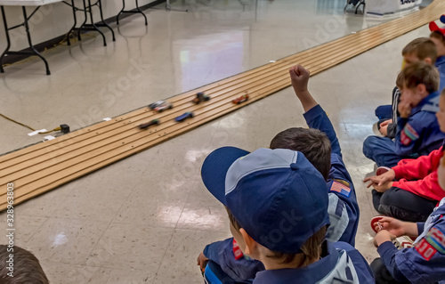 Leinwand Poster Excited cub scout boys at pinewood derby car race
