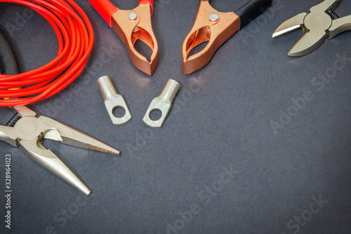 Big kit spare parts and tools, red wires for electrical prepared before repair or setting on black workshop table