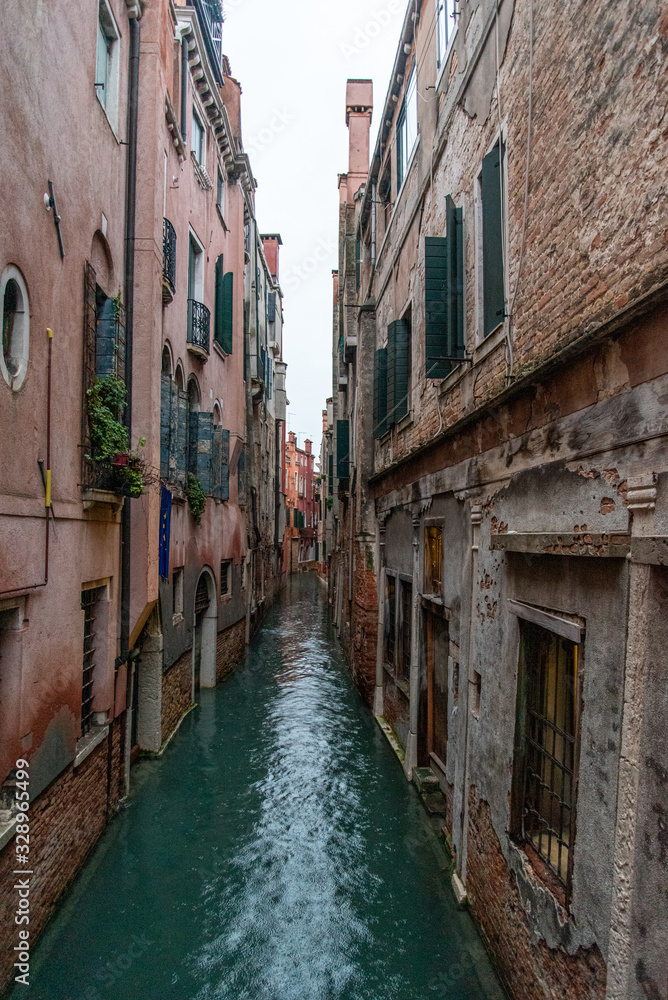 Narrow Canal mirroring the surrounding Houses, Venice/Italy