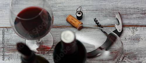 Bild auf Leinwand botellas de vino tinto con sacacorchos, de cantador, corcho y copas de vino sobr