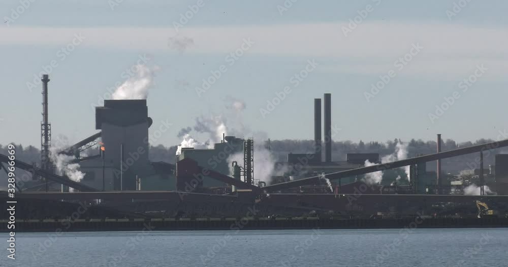 Smoke stack factories with lake in foreground Smoke stack factories with lake in foreground