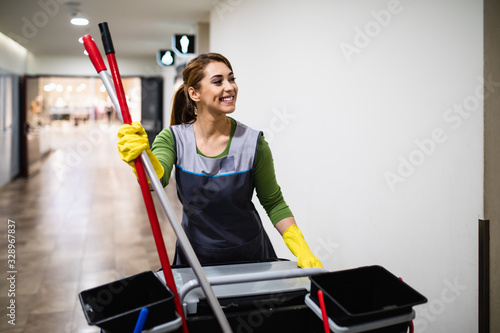 Beautiful young woman cleaning at shopping mall. Cleaning concept. photo