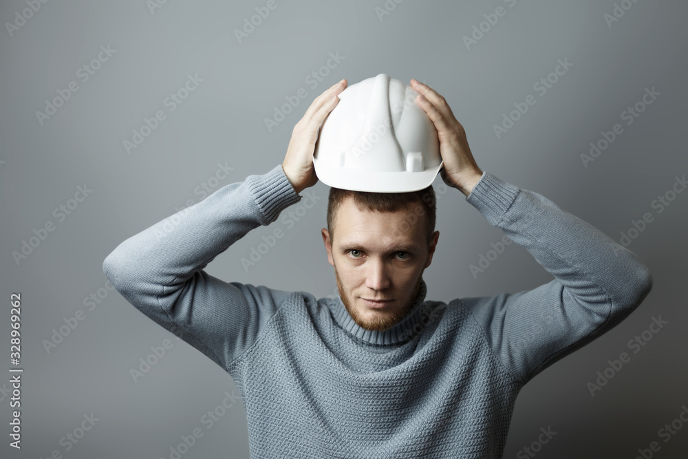 Man puts on a white construction helmet Man puts on a white construction helmet