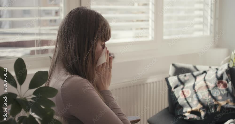 Woman cleaning nose tissue coughing virus coronavirus at home quarantine from behind Woman cleaning nose tissue coughing virus coronavirus at home quarantine from behind
