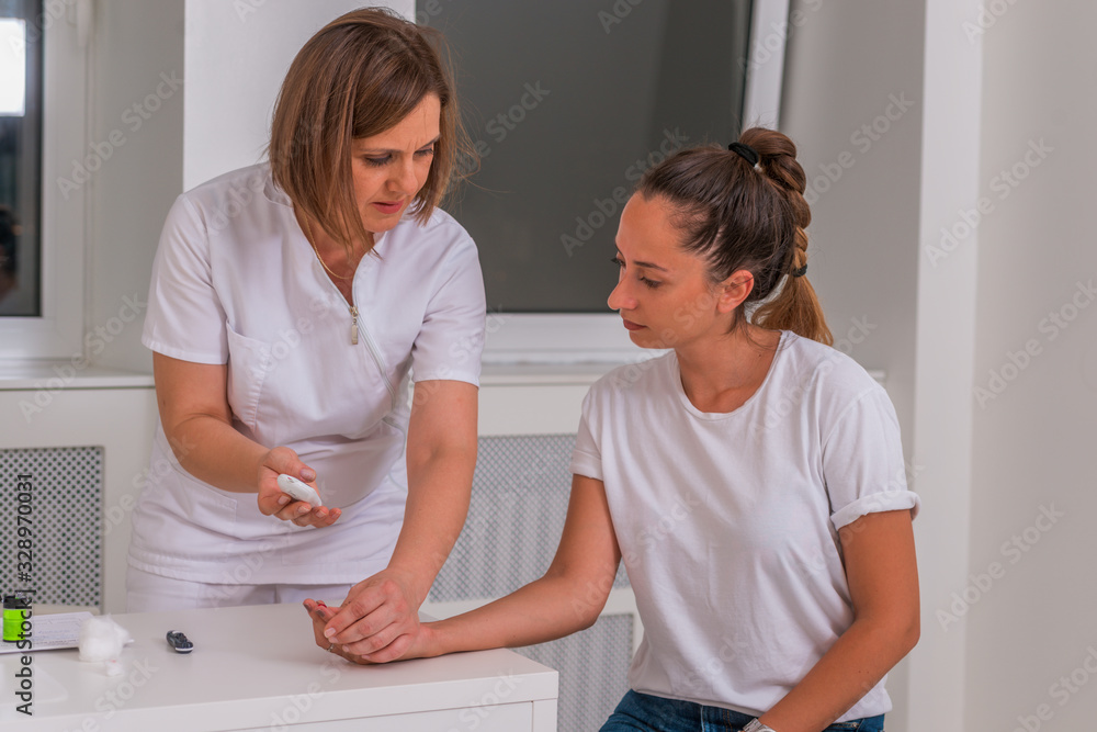 Obraz premium Doctor checking blood sugar level with a glucometer girls levels.