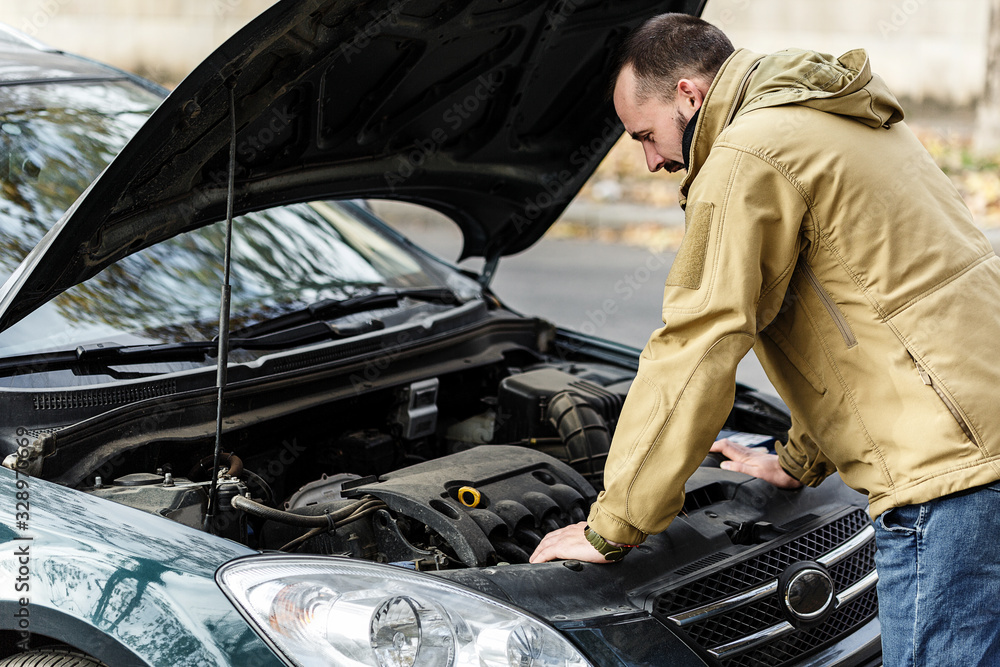 Guy is repairing car on the road Guy is repairing car on the road