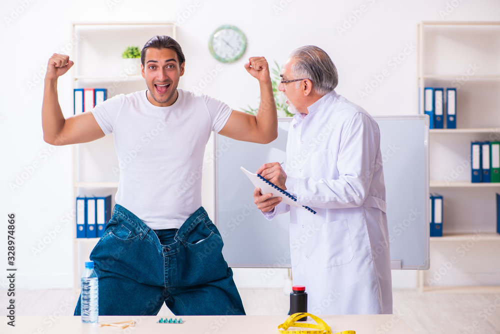 Fototapeta premium Doctor dietician and happy patient wearing large trousers