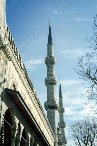Minaret tower of Sultanahmet camii during a December morning in Istanbul, Turkey. Also called Blue Mosque, it is a muslim place of worship, symbol of ottoman architecture and an Istanbul landmark