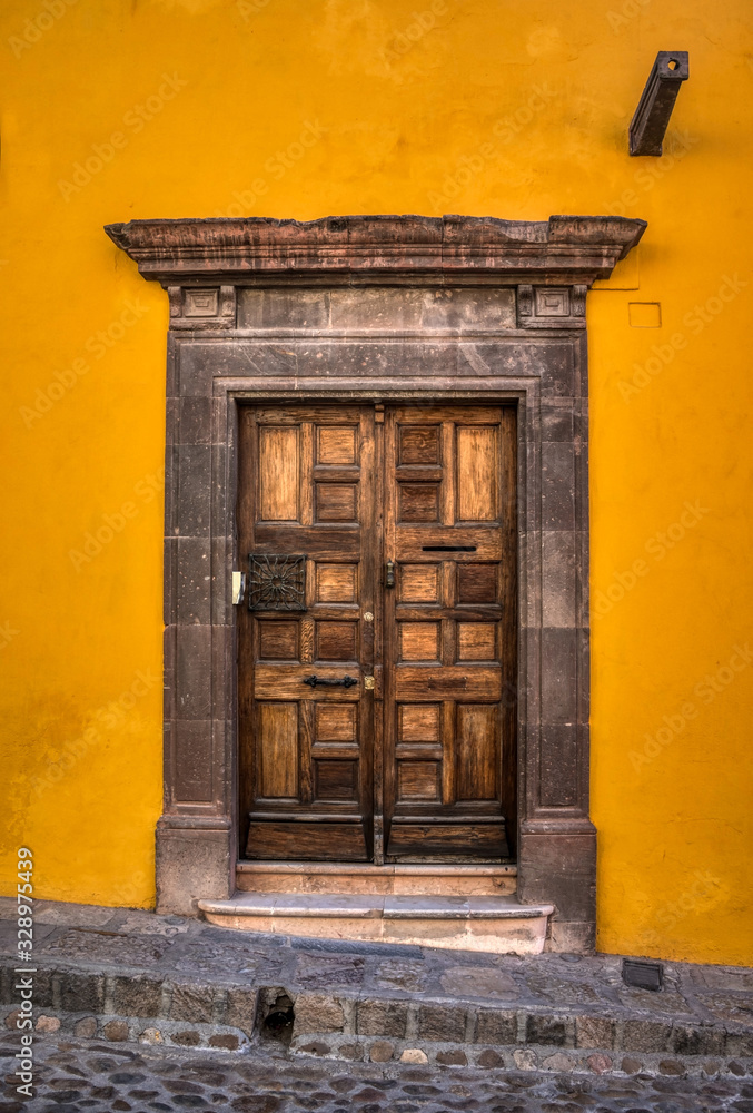 Fototapeta premium An old interesting door with a beautiful stone frame