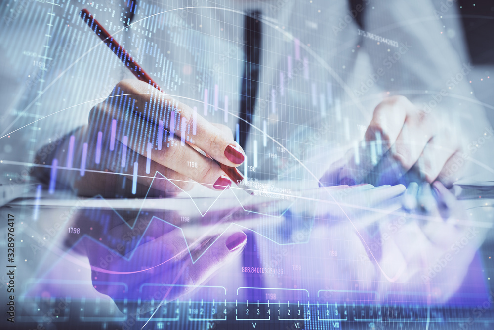 A woman hands writing information about stock market in notepad. Forex chart holograms in front. Concept of research. A woman hands writing information about stock market in notepad. Forex chart holograms in front. Concept of research.