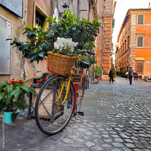  Bike with flowers in the cobbled streets. Old street in Rome, Italy. street view.