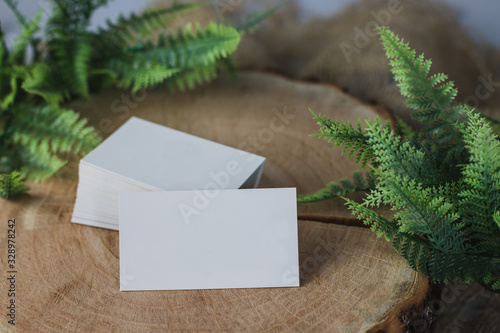 Business card mock up on wooden table with plants. Business card stack template. Corporate stationery set. Business card mockup on rustic composition. Top and front view.