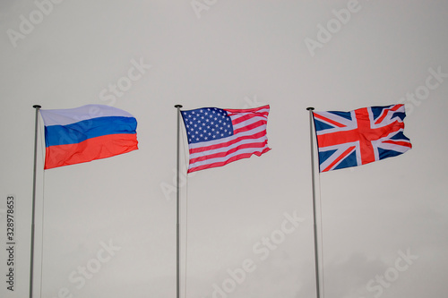 State flags of Russia, USA, Great Britain. Colors - blue, white, red. Background - cloudy sky. Concept of alliance in the Second World War.