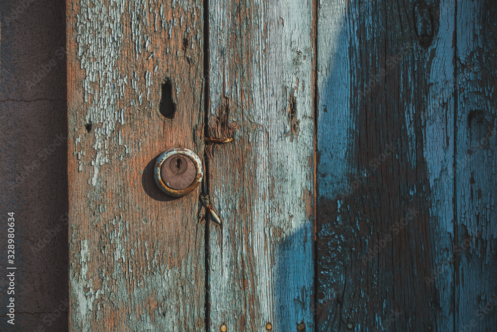 Wooden door with peeling paint and vintage handles with space for text