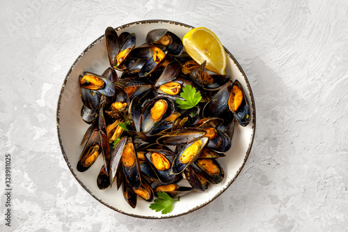 Healthy mussels in white plate on light gray background