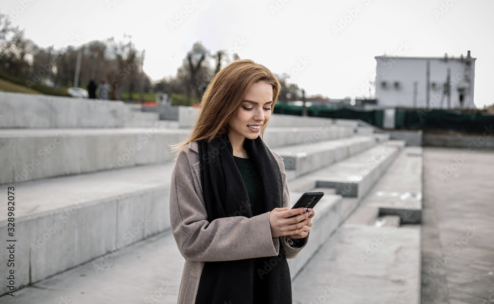 Pretty girl prints a message in a smartphone. Pretty girl prints a message in a smartphone.