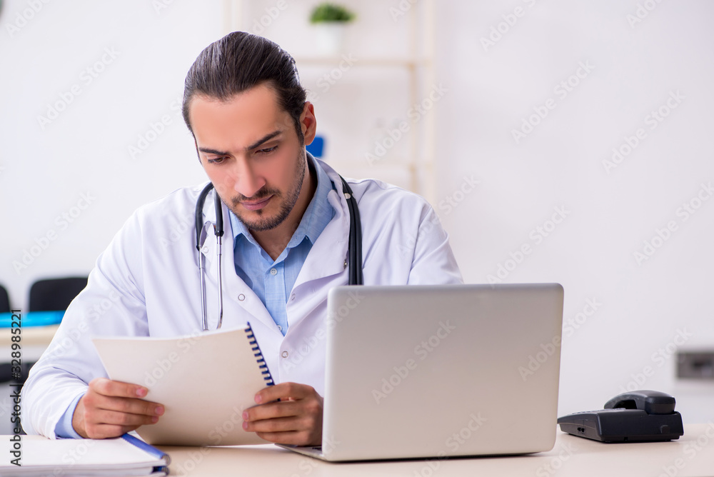Young handsome male doctor working in the clinic Young handsome male doctor working in the clinic