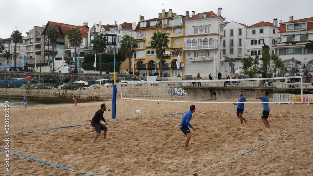 A group of men playing volleyball using their foot at a beach in Portugal Europe A group of men playing volleyball using their foot at a beach in Portugal Europe