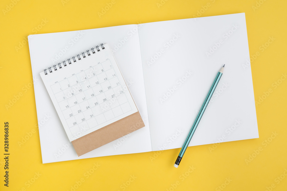 Timeline planning, checklist or business plan with calendar date concept, pencil on blank page note book paper with calendar on yellow background Timeline planning, checklist or business plan with calendar date concept, pencil on blank page note book paper with calendar on yellow background