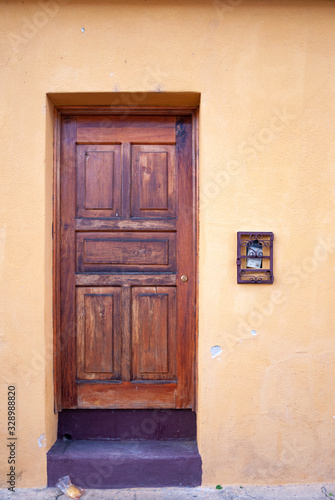 Carved wooden door in colonial house of La Antigua Guatemala, exterior detail shows security and private property, access to home.