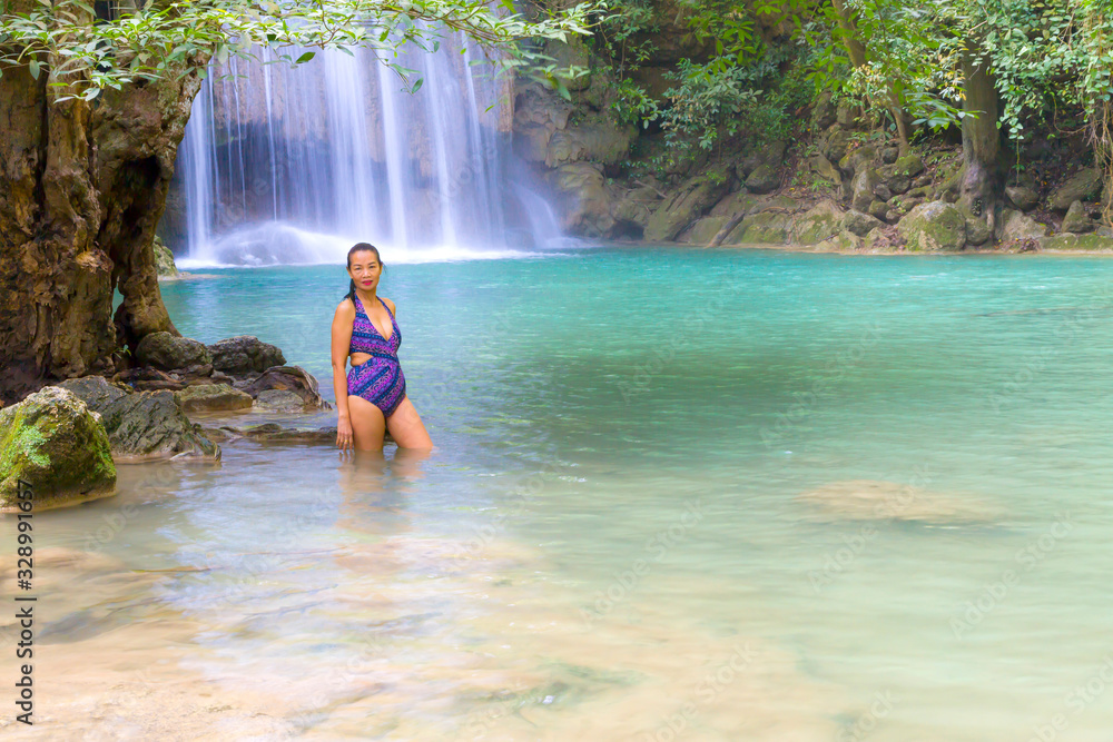 Fototapeta premium Woman with swimsuit stand relax at Erawan Waterfall