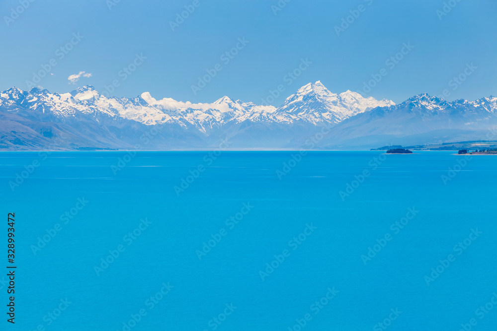 Azure coloured waters of Lake Pukaki with mighty mountains range on the horizon, South Island, New Zealand