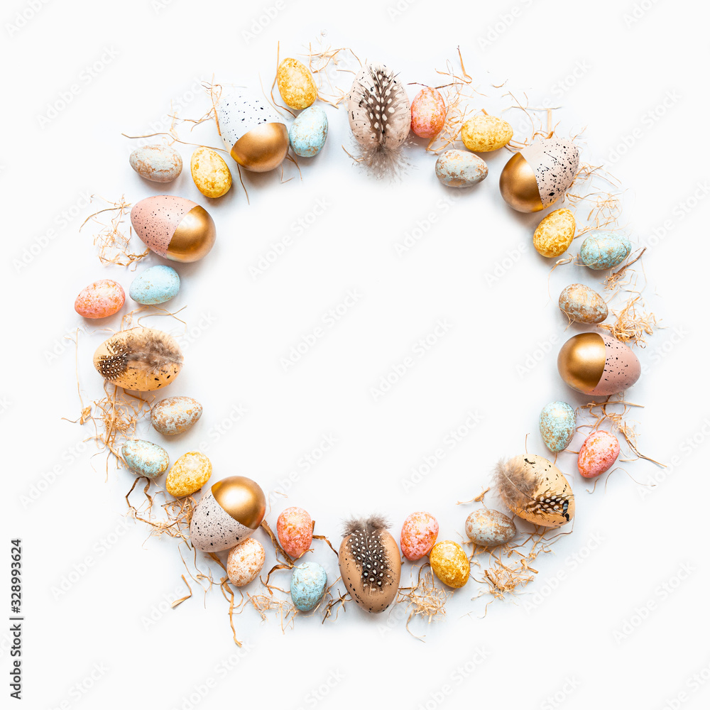 Top view of Easter eggs colored with golden paint in different patterns arranged in circle. White background. Copy space.