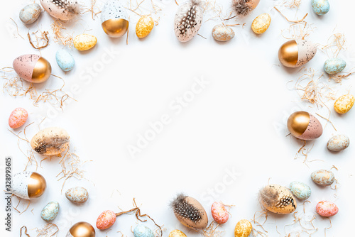 Top view of Easter eggs colored with golden paint in different patterns. White background. Copy space.