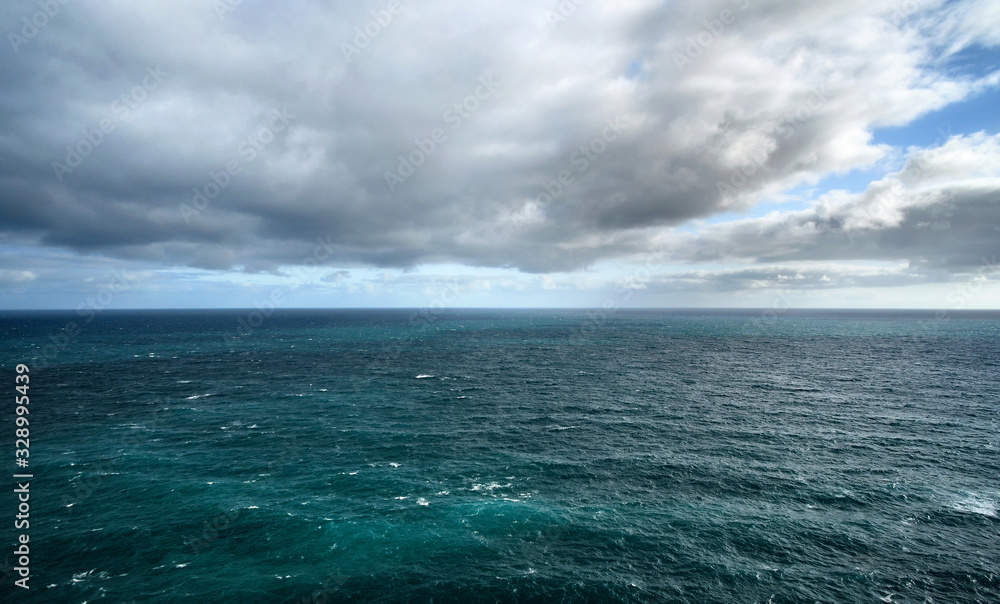Calm deep sea with dramatic clouds and sky.